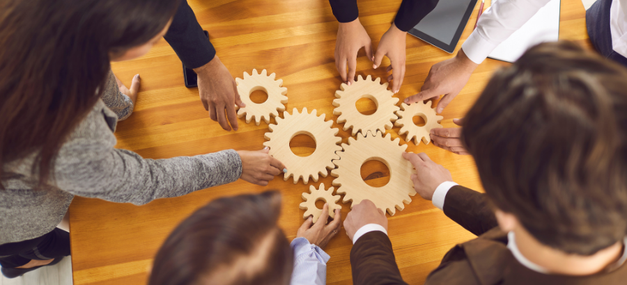 Group of people arranging/connecting wooden gear blocks