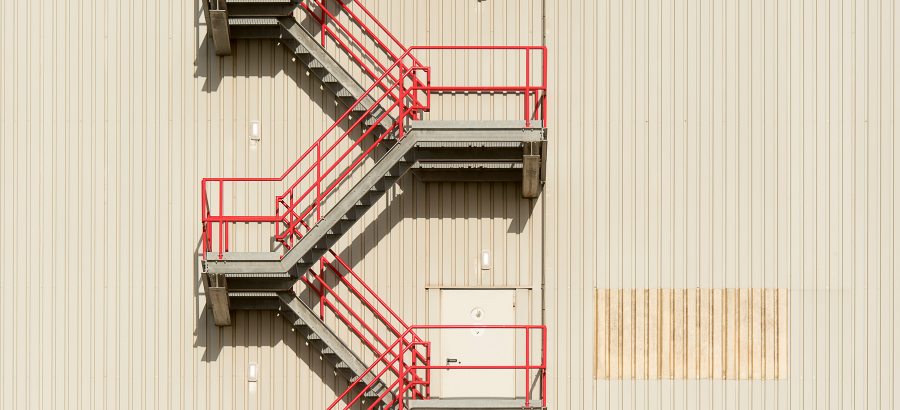 Red-coloured emergency staircase behind a warehouse